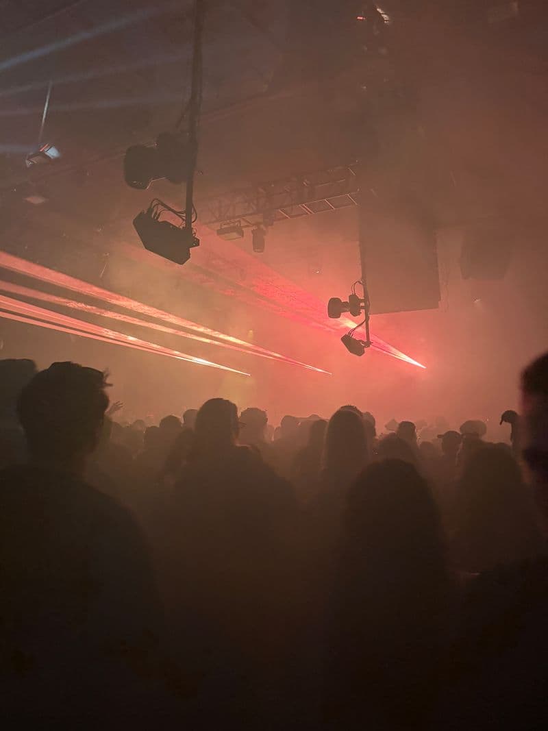 Red light cutting across a crowded warehouse party